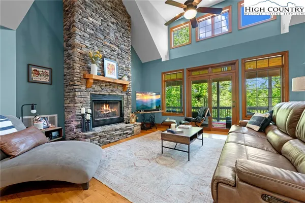 a living room with furniture large window and fireplace