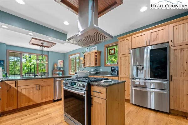 a kitchen with stainless steel appliances granite countertop a stove and a refrigerator