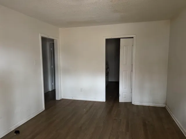 an empty room with wooden floor and closet