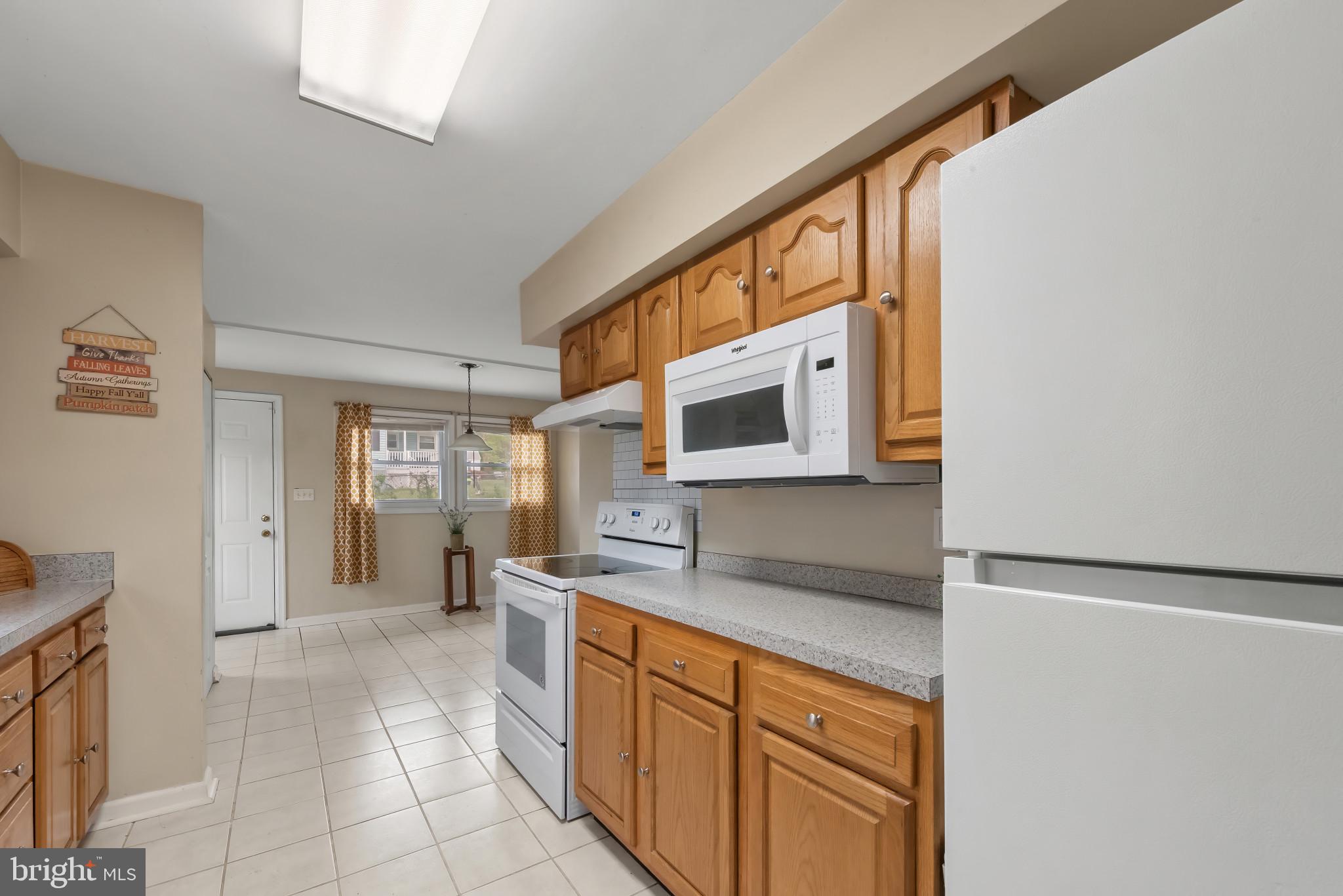 735 Cliffedge Road Baltimore, MD 21208 - Photo 8 of 39 a kitchen with stainless steel appliances granite countertop a sink and a stove top oven