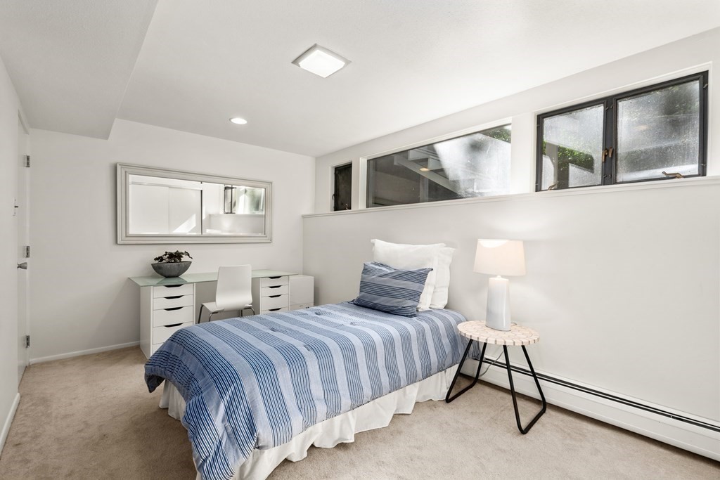 83 Ridgeway Road Weston, MA 02493 - Photo 20 of 32 a bedroom with a large bed and a chandelier