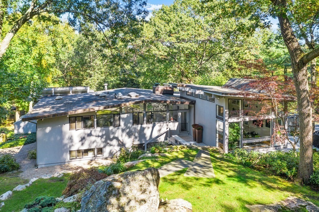 83 Ridgeway Road Weston, MA 02493 - Photo 30 of 32 a view of a patio with table and chairs under an umbrella with large trees