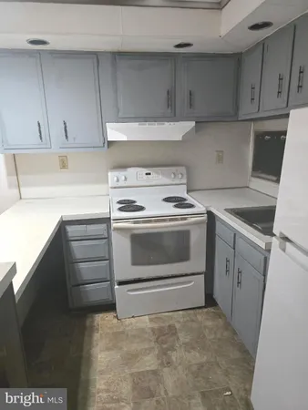 a kitchen with white cabinets and white appliances