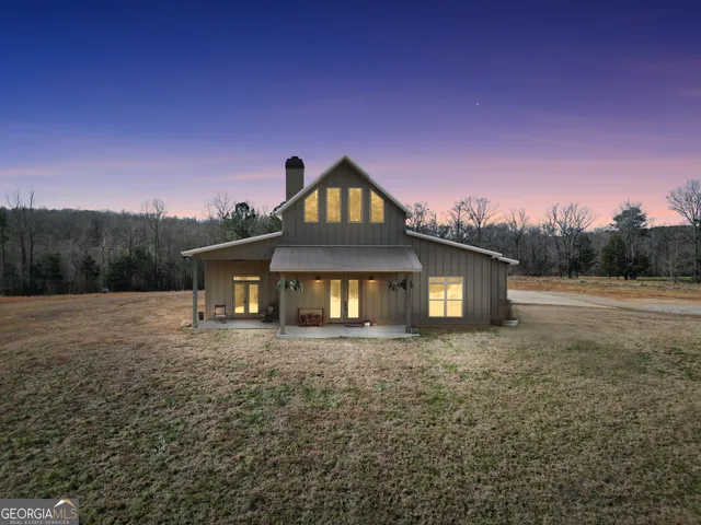 a view of a backyard with couches under an umbrella