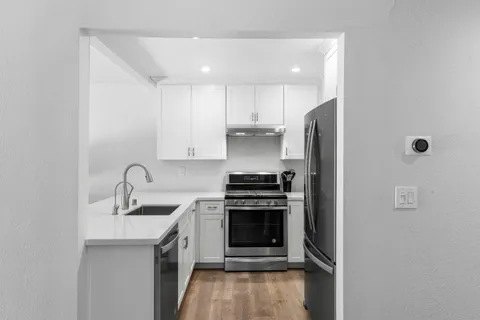 a kitchen with stainless steel appliances granite countertop a sink stove and refrigerator