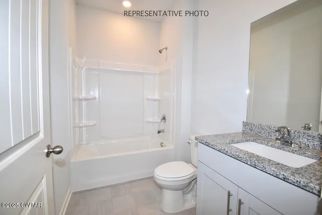 a bathroom with a granite countertop sink a toilet and shower