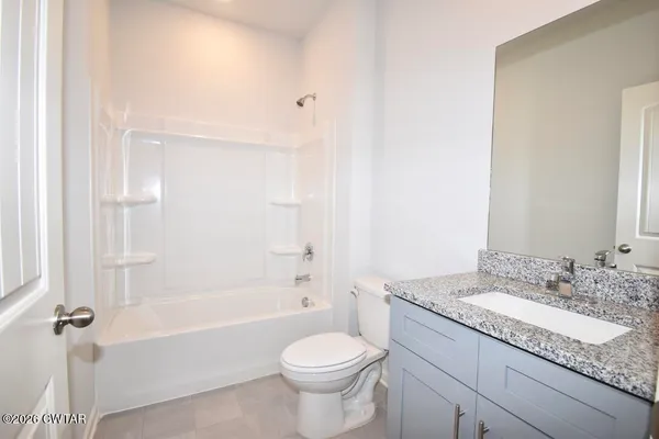 a bathroom with a granite countertop toilet a sink and a bathtub