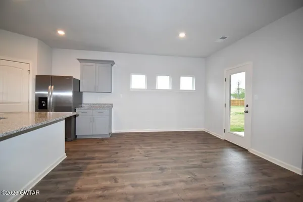 a view of a kitchen with a sink and an empty room