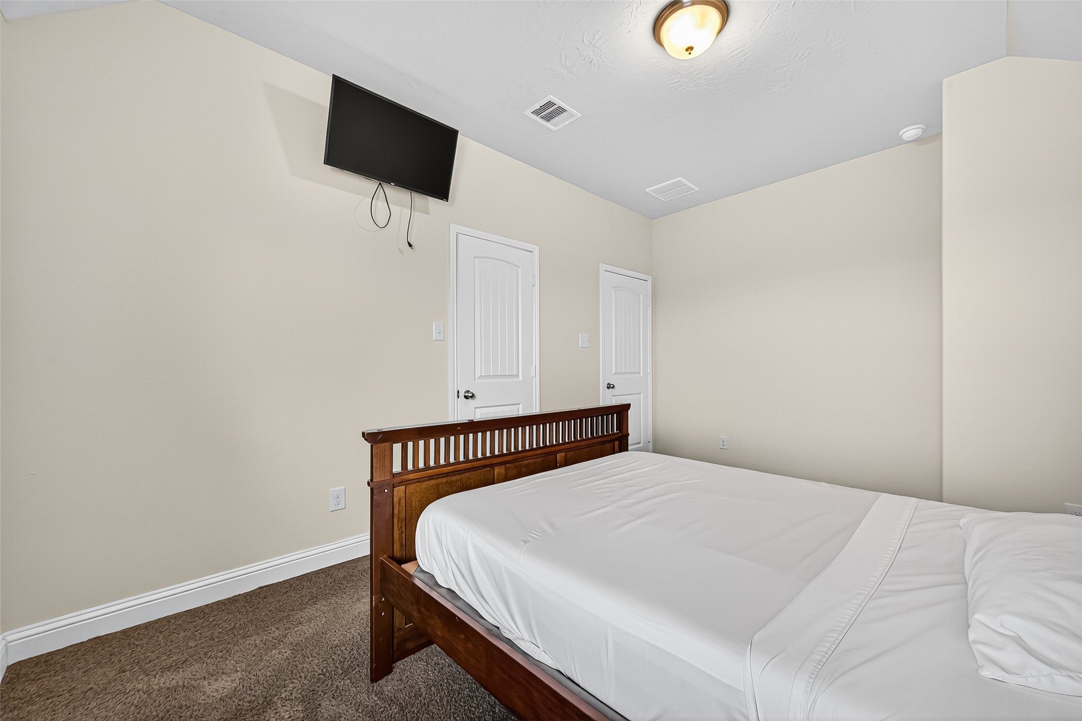 8107 Lockridge Terrace Lane Cypress, TX 77433 - Photo 42 of 50 This second view of the upstairs secondary bedroom highlights its cozy proportions and functional layout. With a large window for natural light, neutral walls, and wood-look flooring, it offers a peaceful space perfect for guests, kids, or a home office. The mounted TV adds a ready-to-enjoy touch.