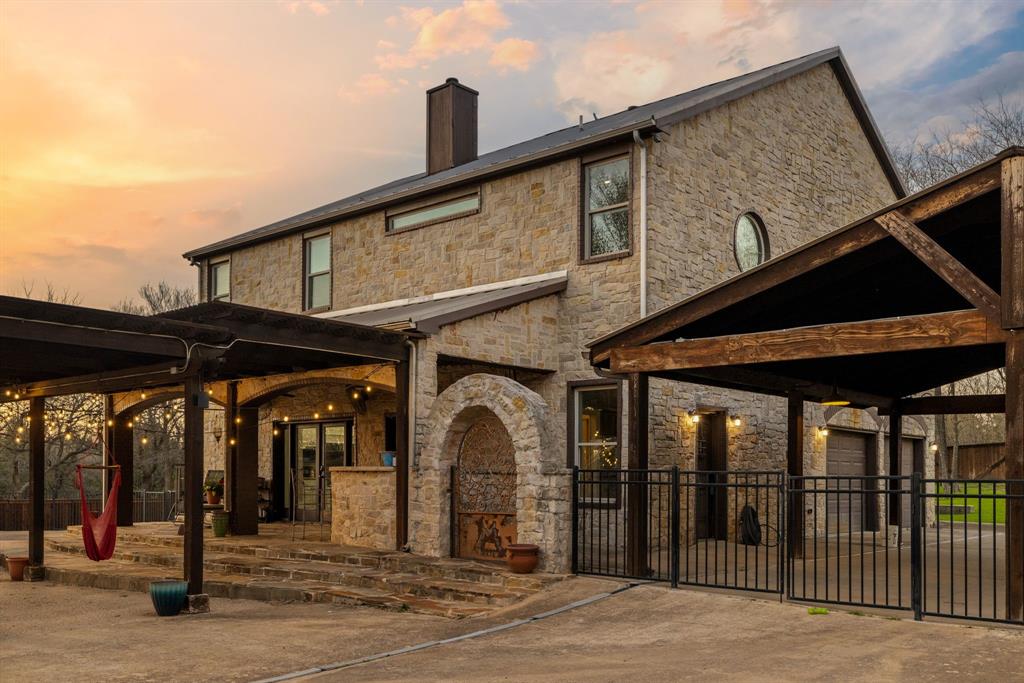 689 Jim Cannon Road Van Alstyne, TX 75495 - Photo 3 of 35 Back of house at dusk with a patio, stone siding, and a chimney