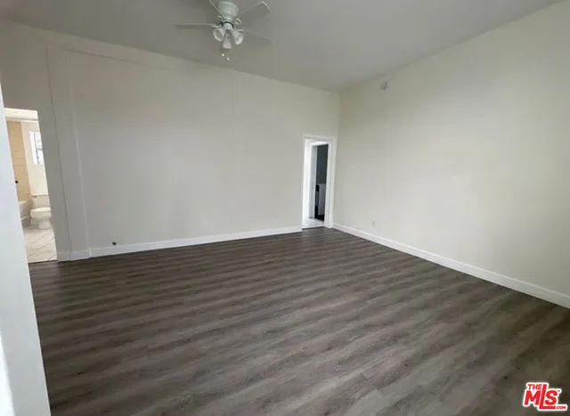 a view of an empty room with wooden floor