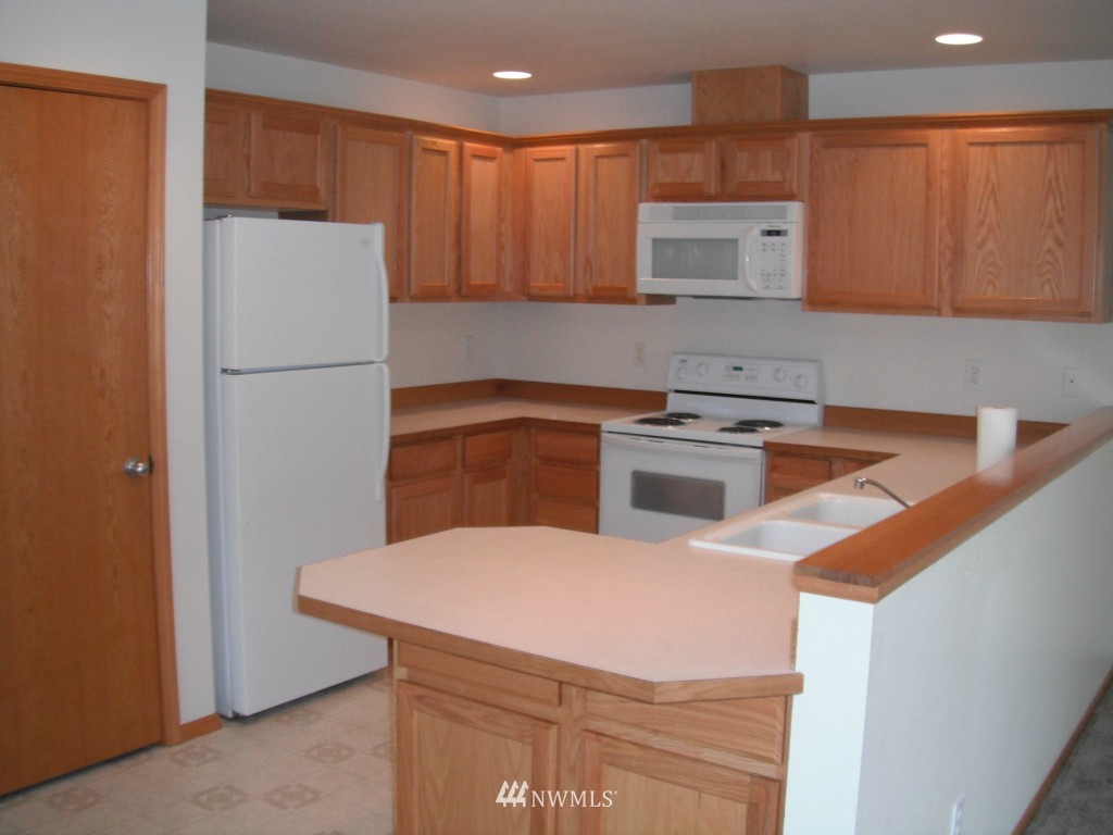 7522 Lower Ridge Road Everett, WA 98203 - Photo 2 of 6 a kitchen with a sink a refrigerator and cabinets