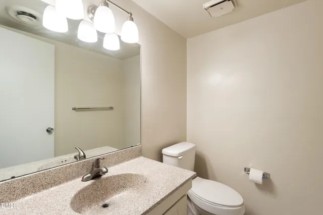 a bathroom with a sink a toilet and mirror