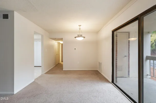 an empty room with fan and entrance