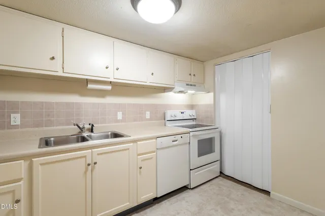 a kitchen with white cabinets and white appliances