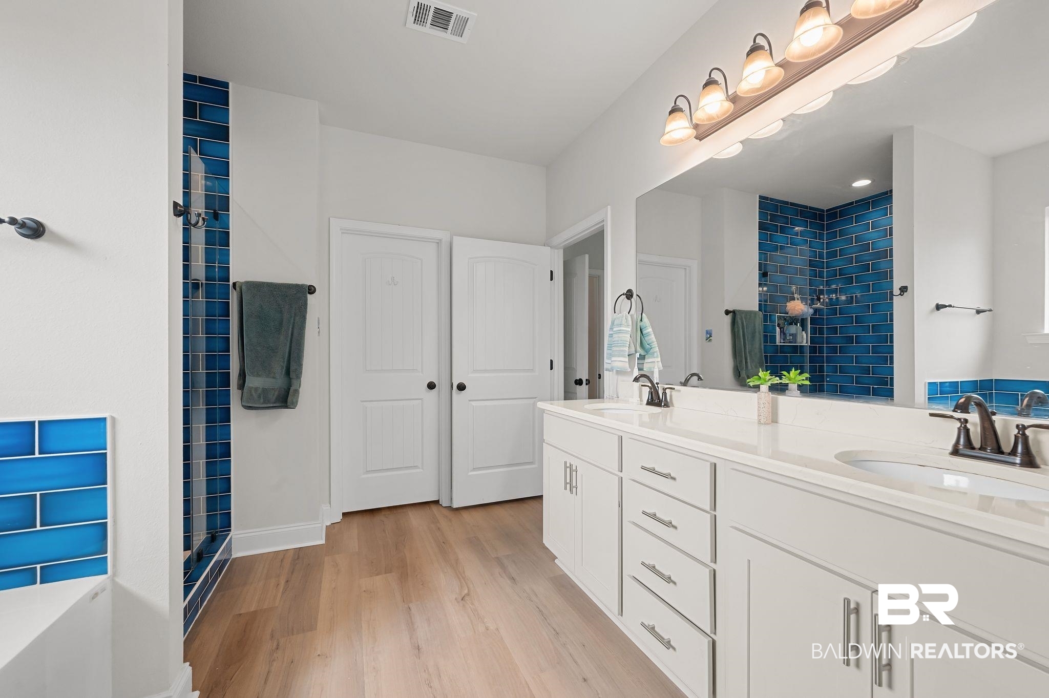 1165 Stella Road Foley, AL 36535 - Photo 23 of 42 Bathroom with a stall shower, wood finished floors, double vanity, and baseboards