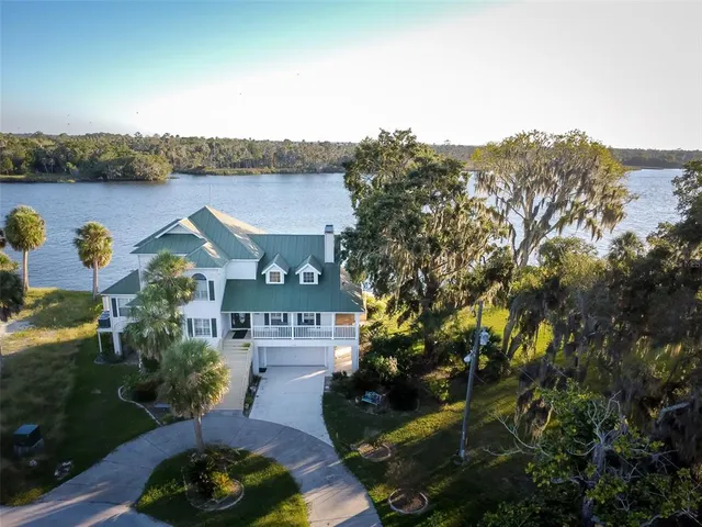 an aerial view of a house with a garden and lake view