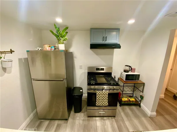 a kitchen with stainless steel appliances a refrigerator a stove a microwave and a dining table