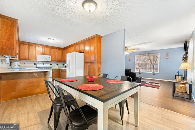 a open dining room with stainless steel appliances furniture a window and kitchen view