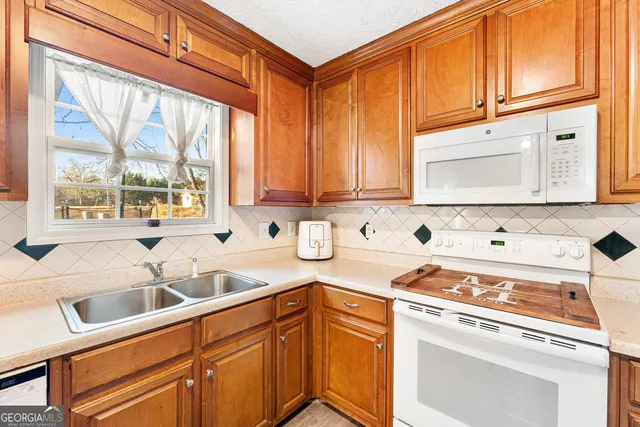 a kitchen with stainless steel appliances granite countertop a sink a stove and cabinets