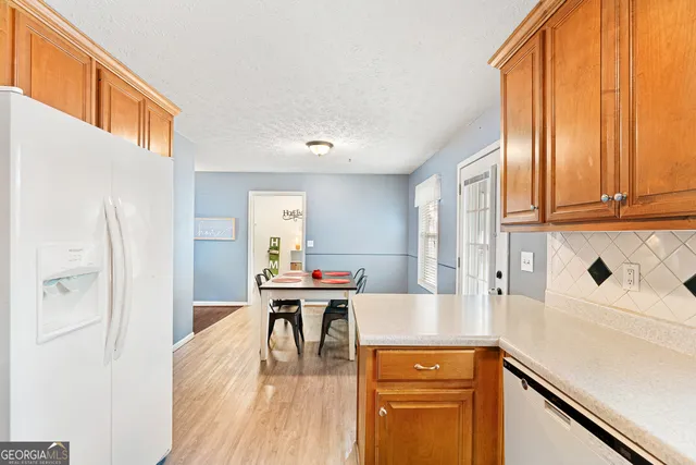 a view of a kitchen with a dining table chairs and a window