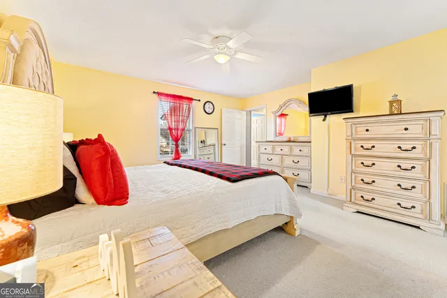a bedroom with a bed a dresser and a flat screen tv