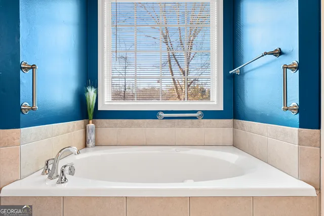 a white bath tub sitting in a bathroom next to a window
