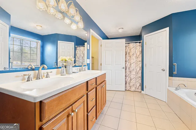 a large white kitchen with a sink a large window and stainless steel appliances
