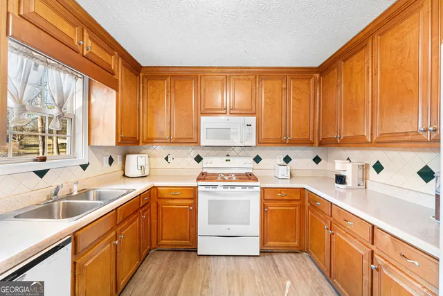 a kitchen with a sink stove top oven and cabinets