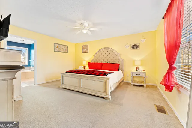 a spacious bedroom with a bed and a flat screen tv