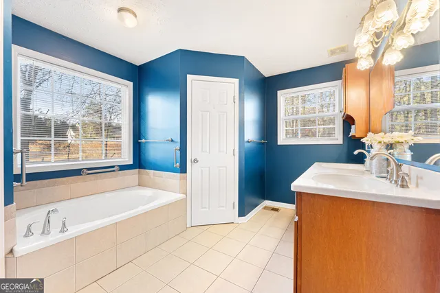 a bathroom with a tub sink and mirror