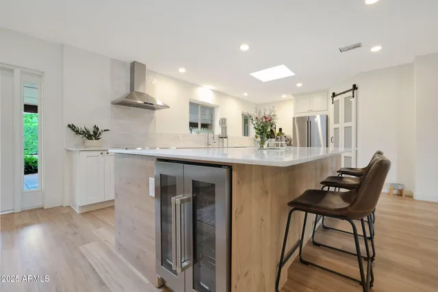 a kitchen with kitchen island stainless steel appliances a table and chairs in it