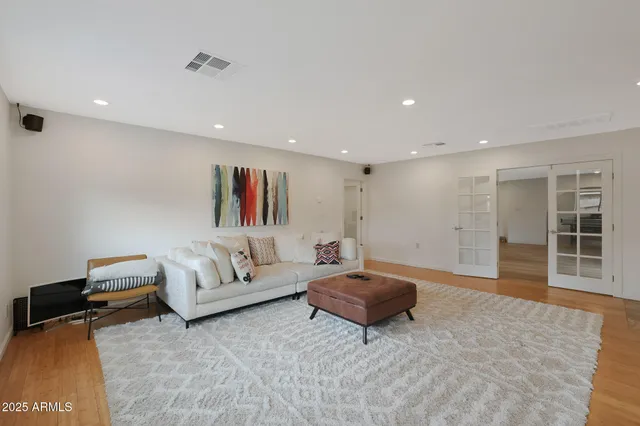 a living room with furniture a wooden floor and potted plant