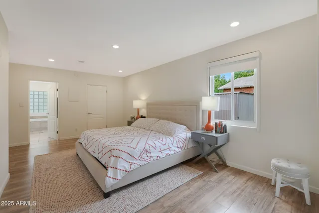 a bedroom with a bed and a painting on the wall