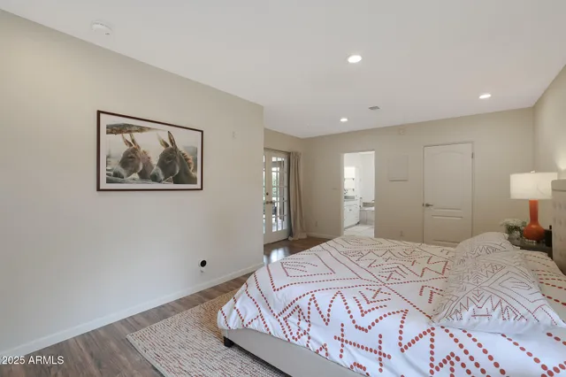 a spacious bedroom with a bed and a painting on the wall