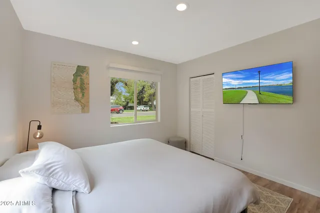 a bedroom with a large bed and a flat screen tv