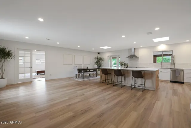 a view of a kitchen with kitchen island a sink dishwasher a dining table and chairs