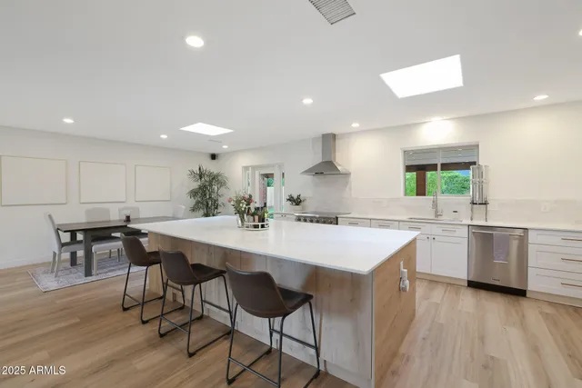 a kitchen with a stove a table and chairs in it