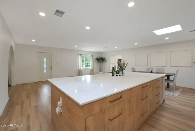 a view of a kitchen island a sink wooden floor and a living room
