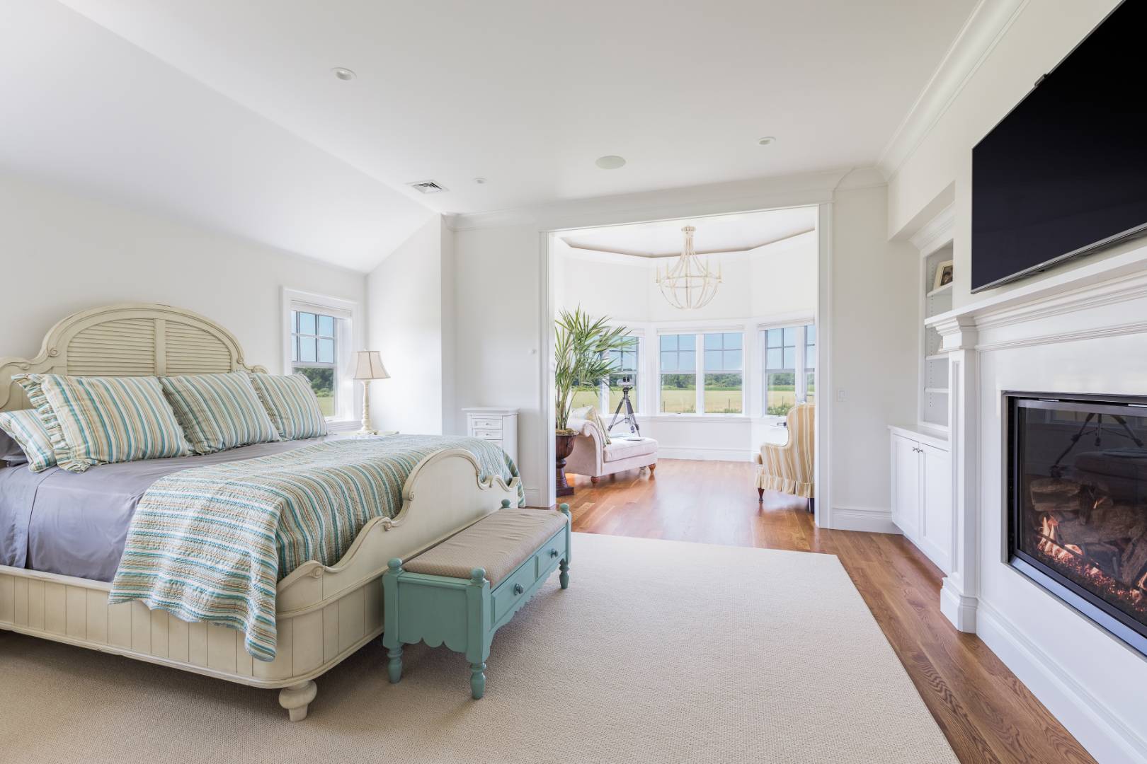 170 Scuttle Hole Road Water Mill, NY 11976 - Photo 12 of 35 a spacious bedroom with a bed a flat screen tv and balcony view