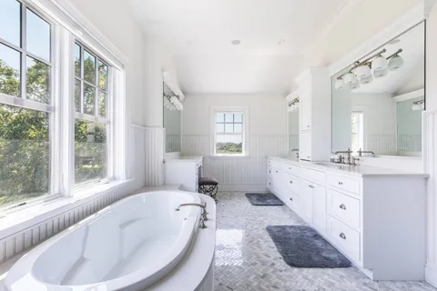 a spacious bathroom with a large tub sink and mirror