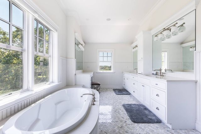 a spacious bathroom with a large tub sink and mirror