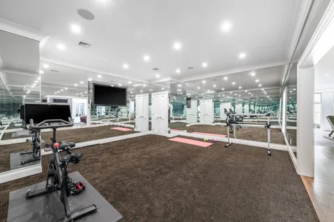 a view of a room with gym equipment and a fireplace