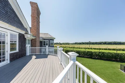 a view of a deck with a table and chairs next to a yard