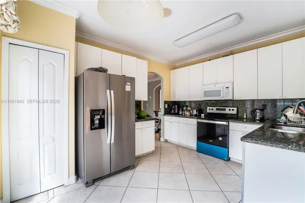 a kitchen with stainless steel appliances granite countertop a stove a sink and a refrigerator