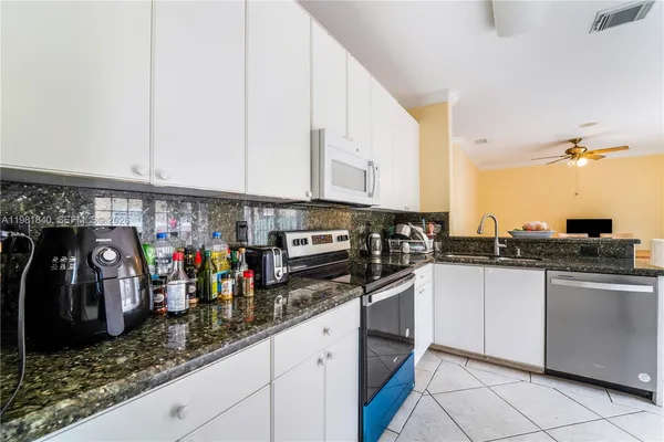 a kitchen with stainless steel appliances kitchen island granite countertop a refrigerator and a sink