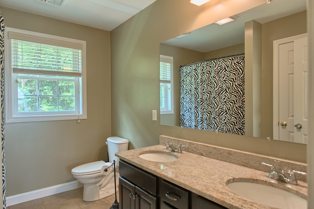 72 Clement Road Dracut, MA 01826 - Photo 21 of 30 a bathroom with a granite countertop toilet a sink and a mirror