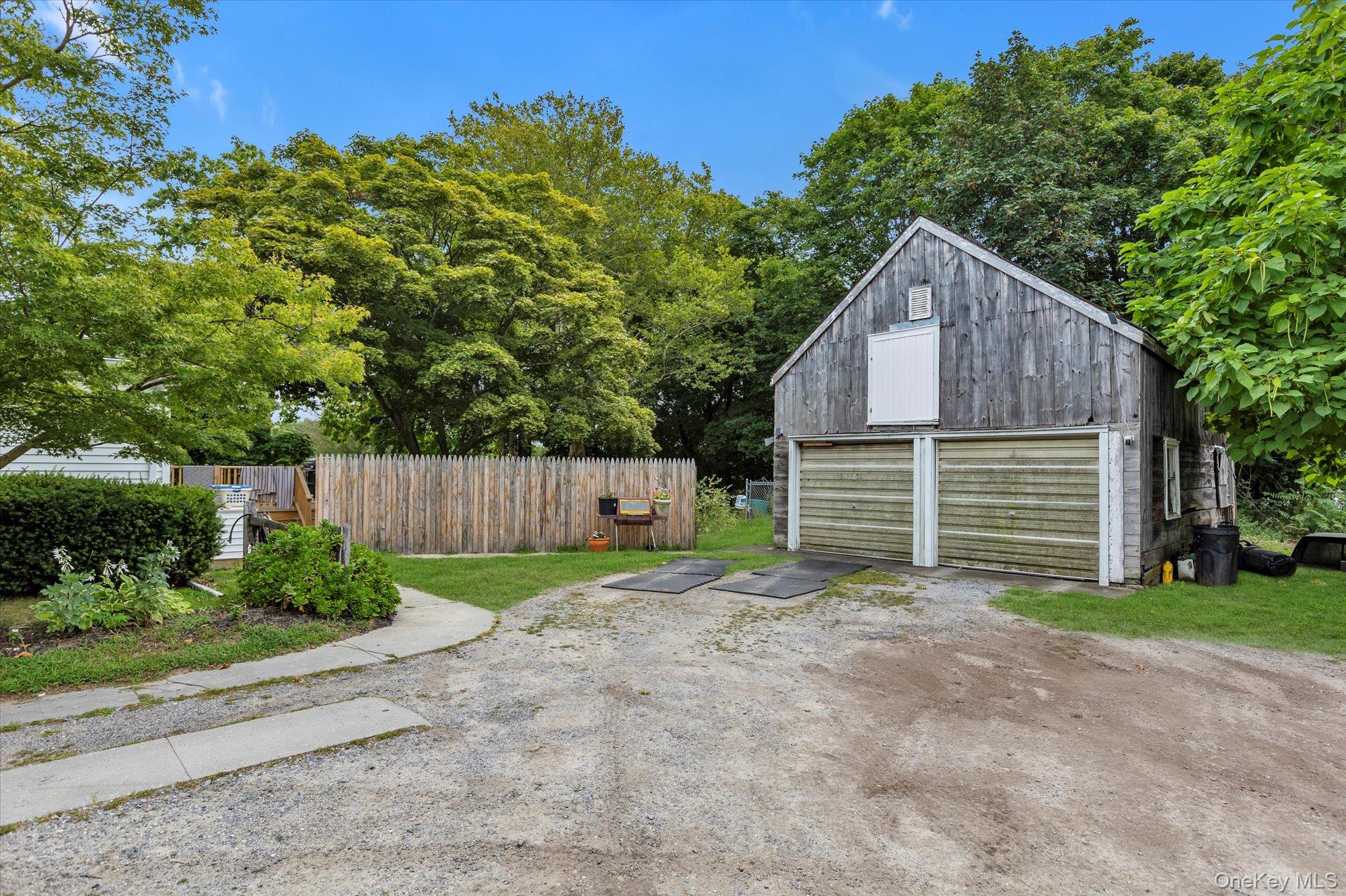 653 Main Road Aquebogue, NY 11901 - Photo 6 of 19 a backyard of a house with plants and large tree