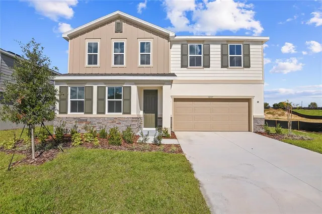 a front view of a house with a garden and yard