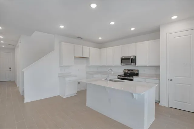 a kitchen with white cabinets and stainless steel appliances